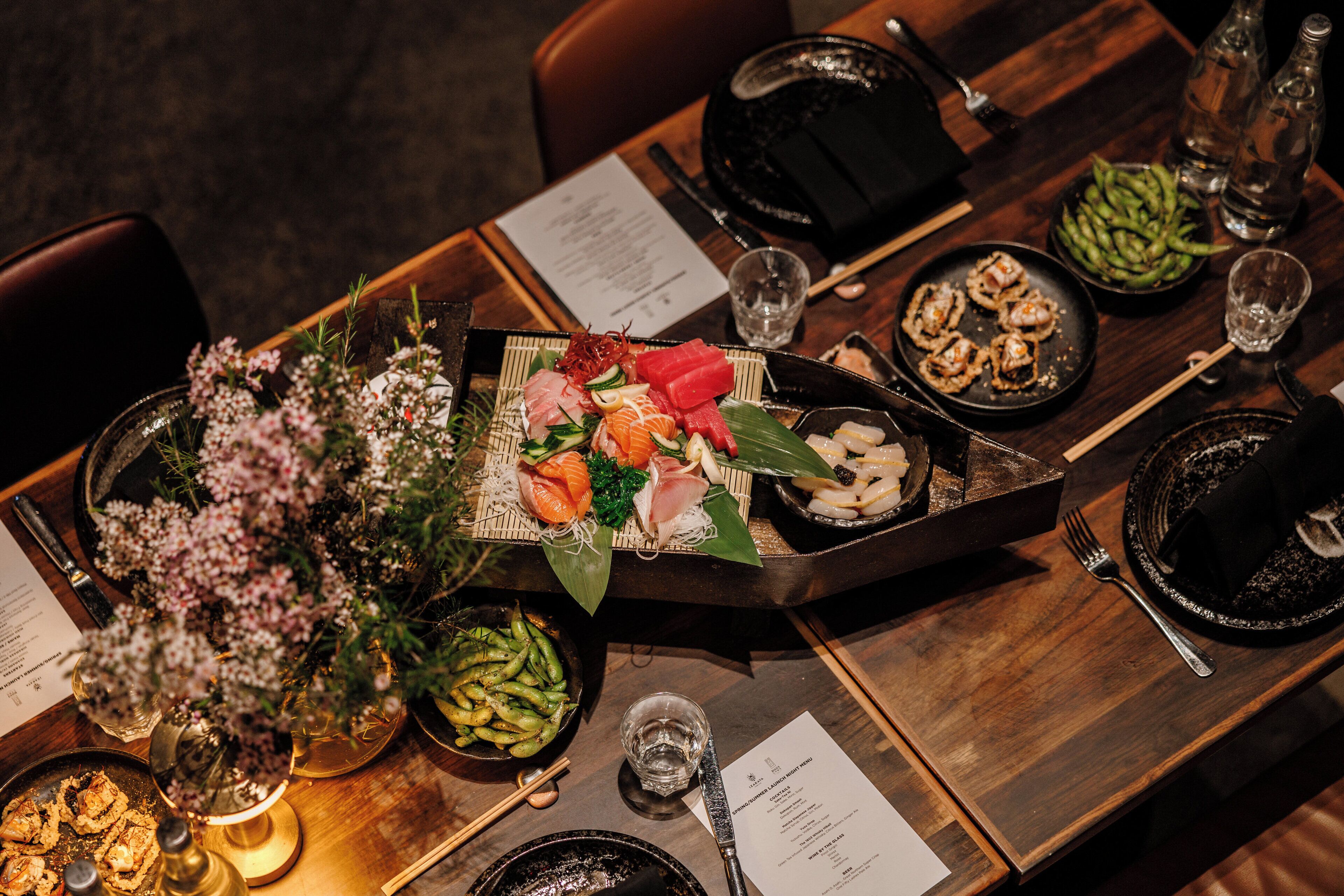 A dining table set with various dishes, chopsticks, and a menu.