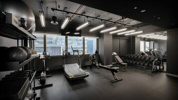 A modern gym with treadmills, weight machines, and free weights.