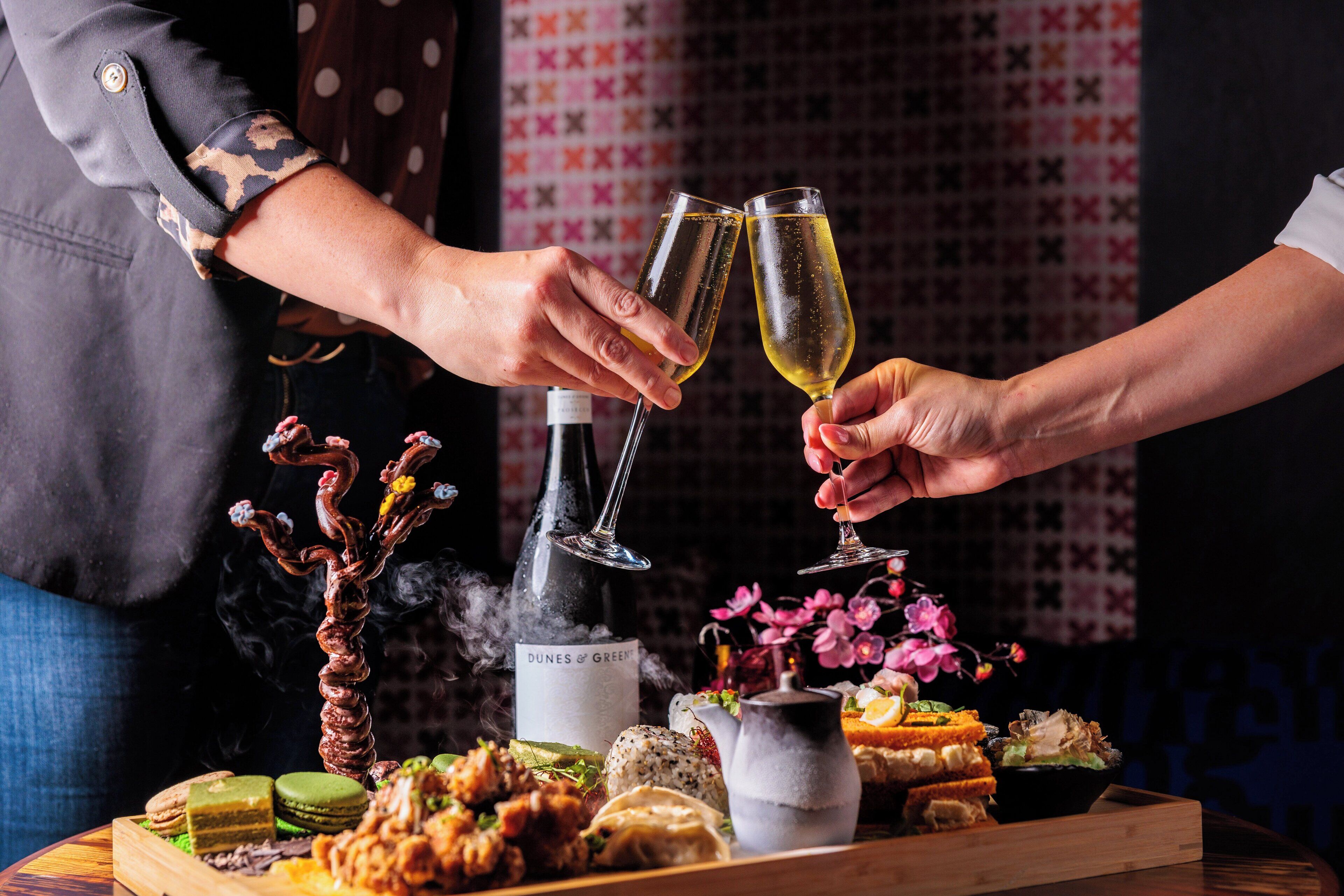 A table with a variety of food items and a bottle of wine.