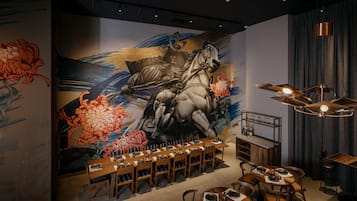 Un restaurante con un mural de un caballo y flores, mesas de madera y una zona de bar.