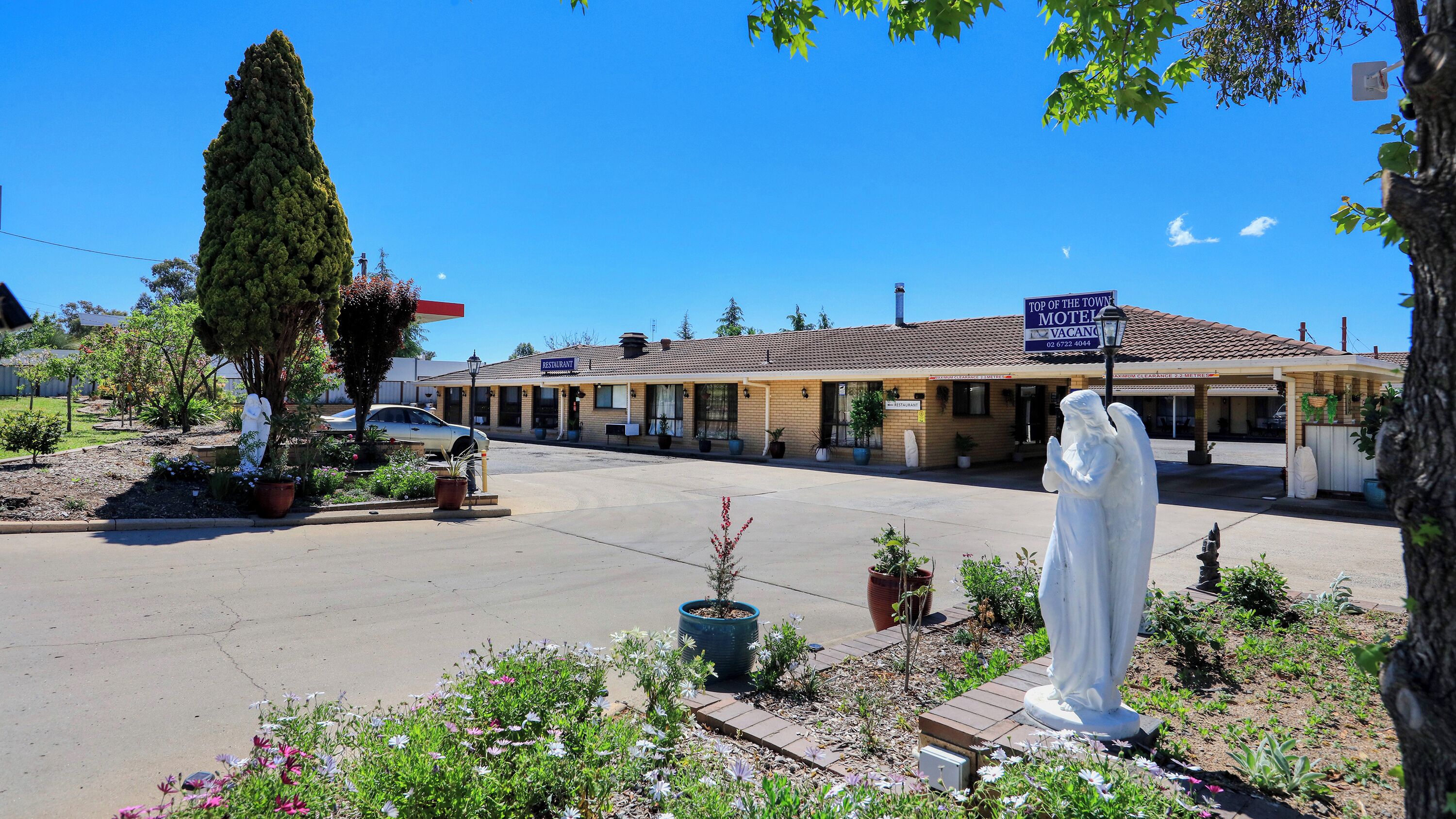 A motel with a sign indicating it's the top of the town.