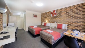 A hotel room with two beds, a desk, a chair, and a dining table with a few items on it. - Top Of The Town Motel (Inverell)