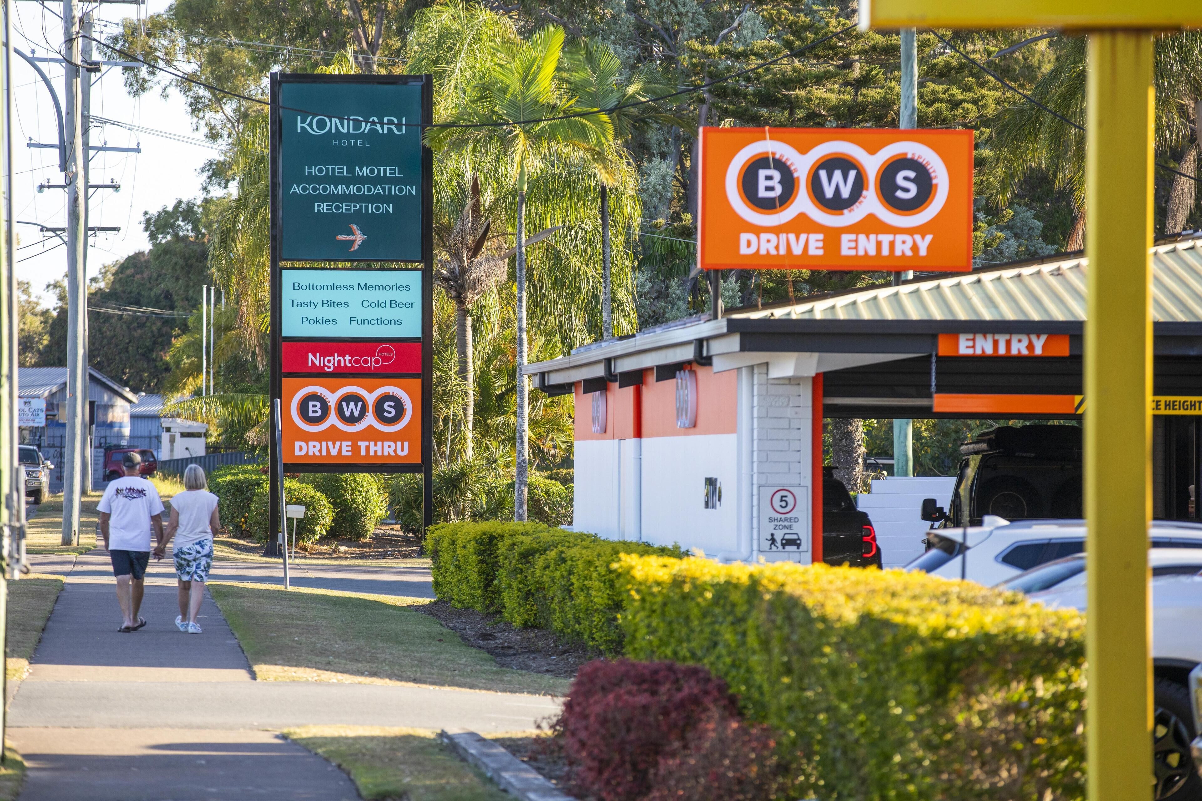 A hotel sign with amenities and a drive entry sign.