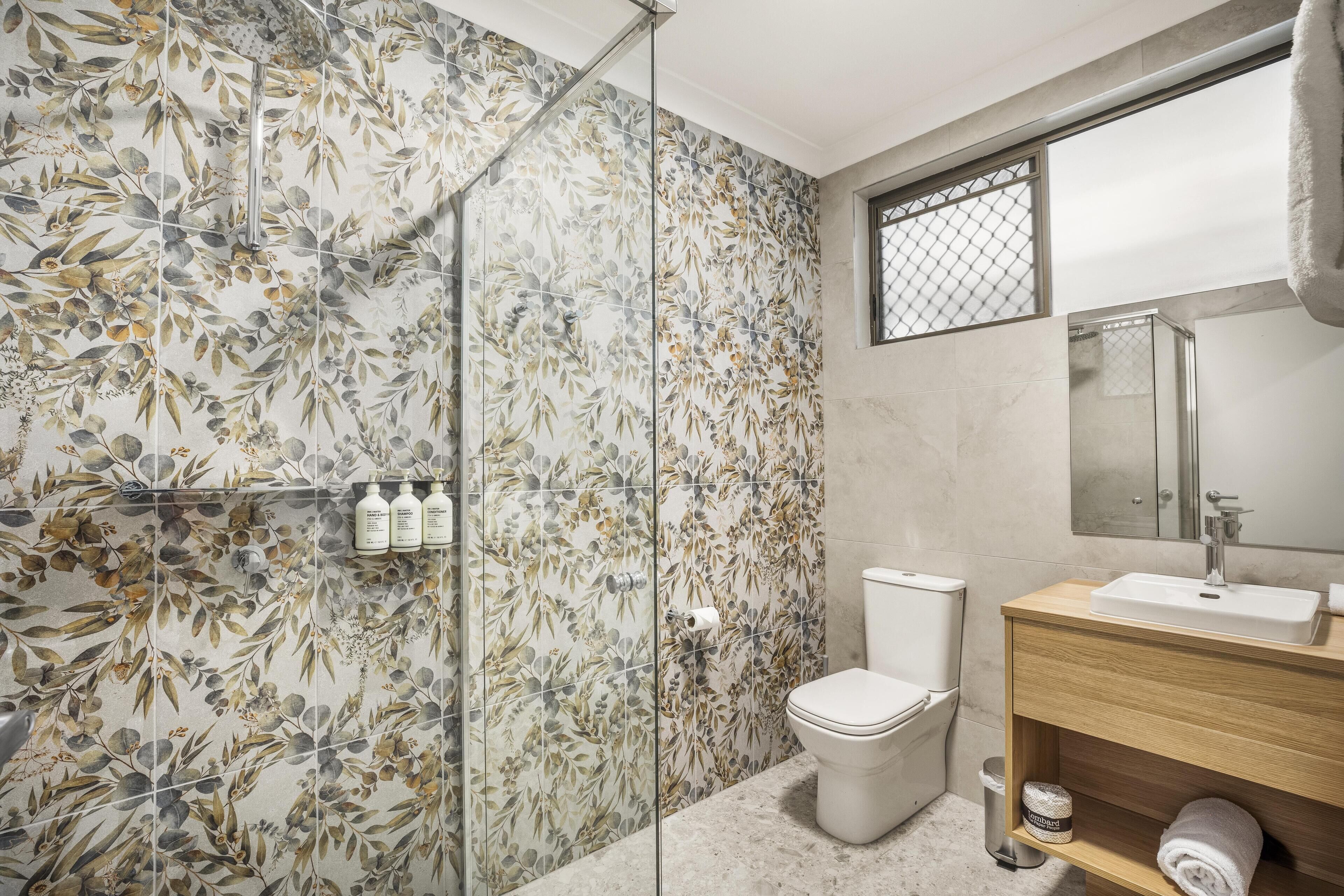 A bathroom with a shower, toilet, and sink.