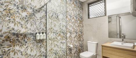 A bathroom with a shower, toilet, and sink.