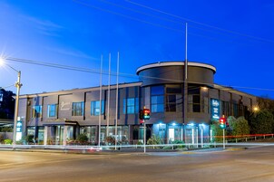 Un edificio moderno con una esquina curva, ventanas amplias y un cartel que dice 'Barbey's Restaurant'.