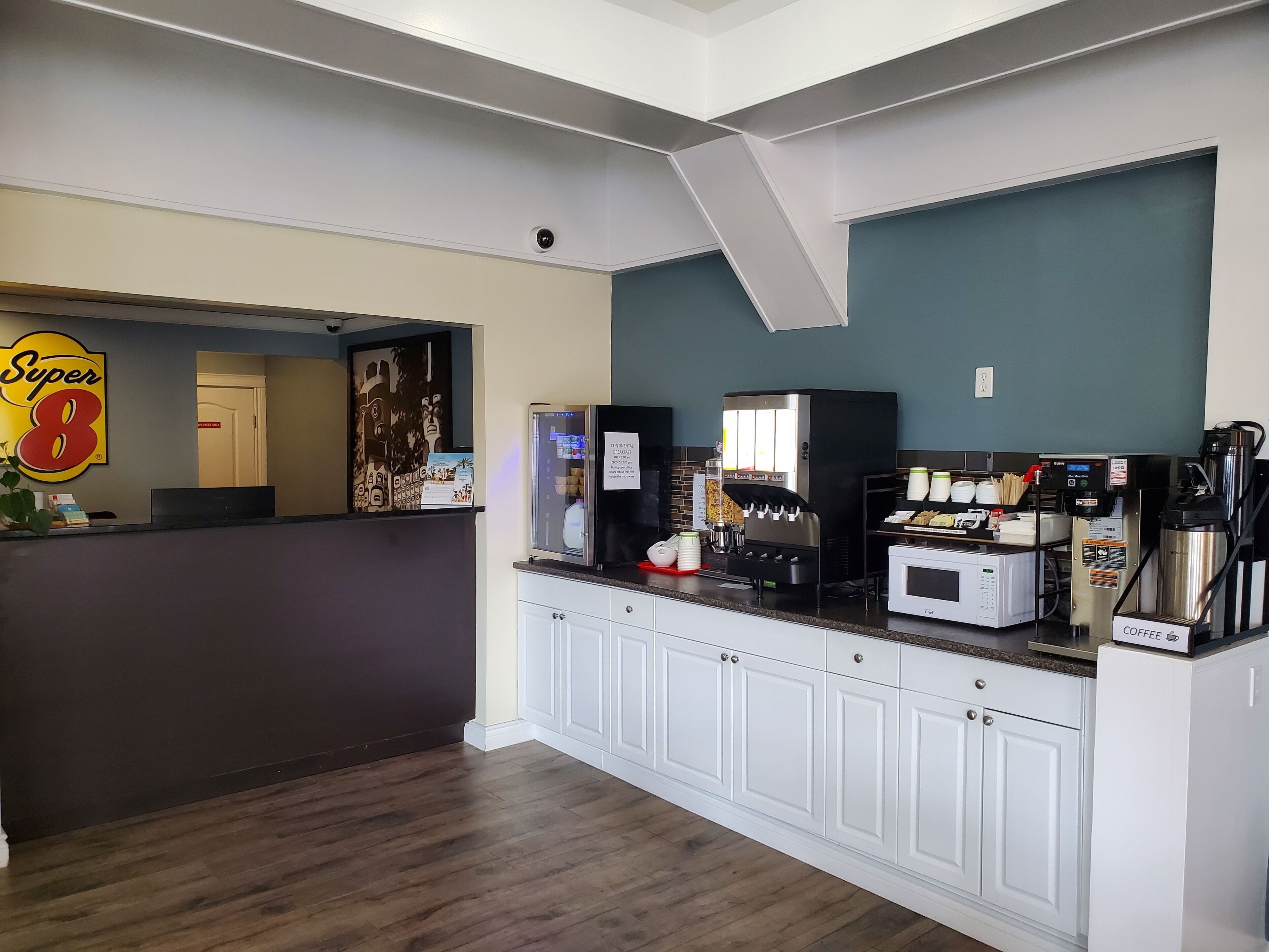 Un espace café moderne équipé d’une machine à café, d’un four à micro-ondes et d’un distributeur de café.