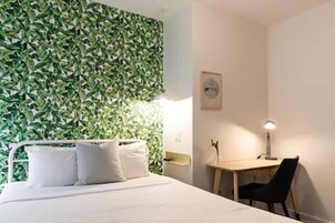 Een slaapkamer met een bed, een bureau en een stoel.