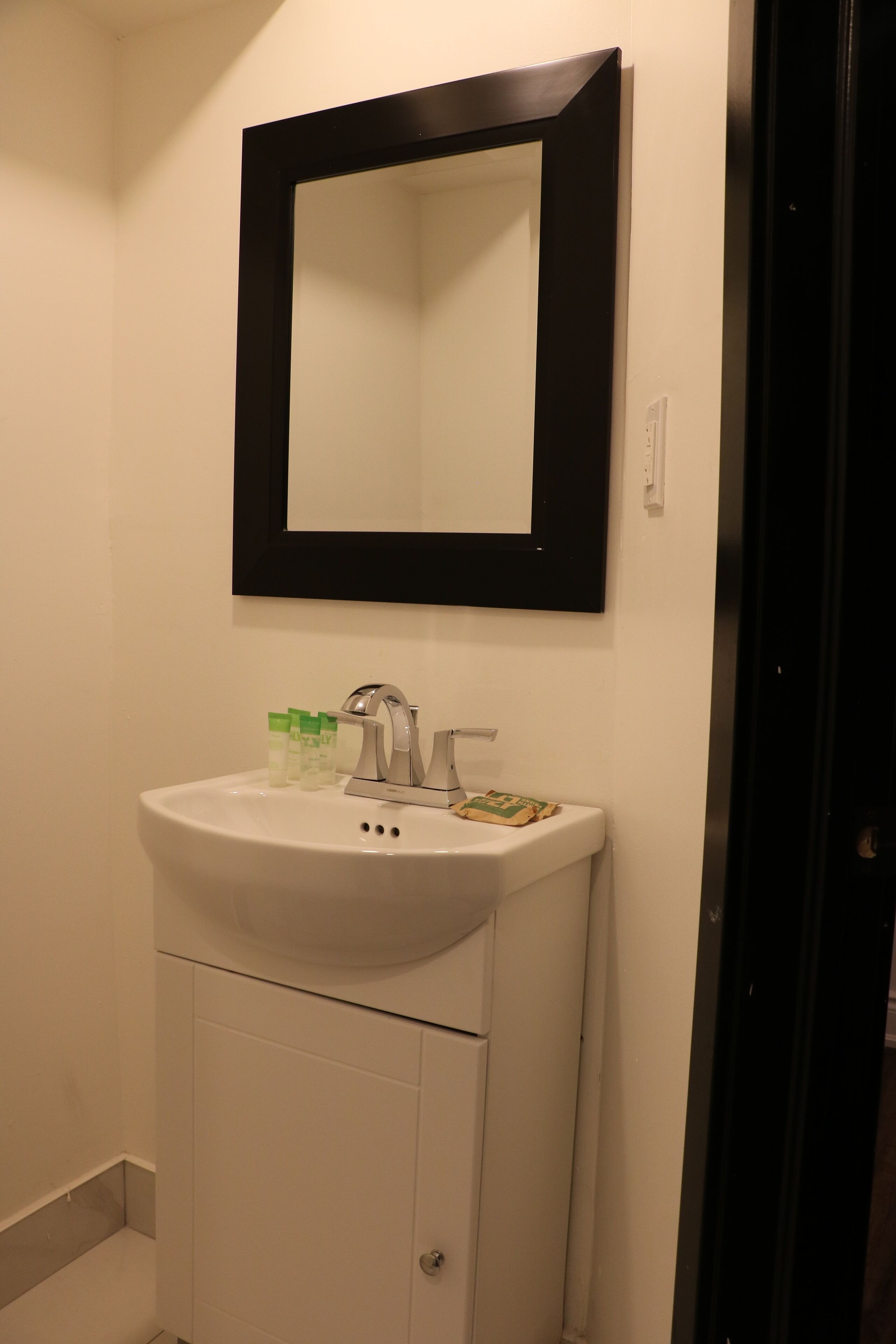 Une salle de bain avec un lavabo blanc, un miroir et des articles de toilette.