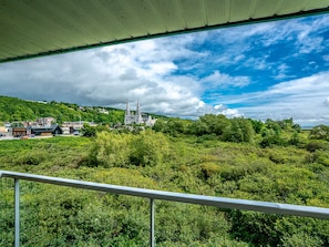 A view of a lush green landscape with a church and buildings in the distance. - Quality Suites (Ste Anne de Beaupre)