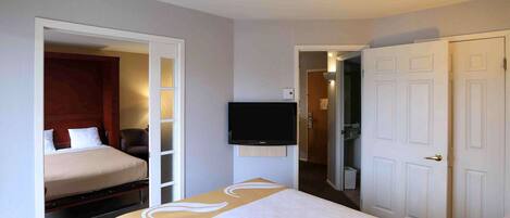 A hotel room with a bed, a television, and a wardrobe.