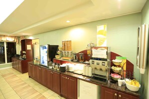 A buffet setup with various food items and kitchen appliances.