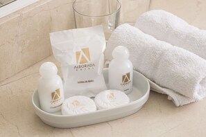 Toiletries on a tray, including a shower bag, bottles, and towels.