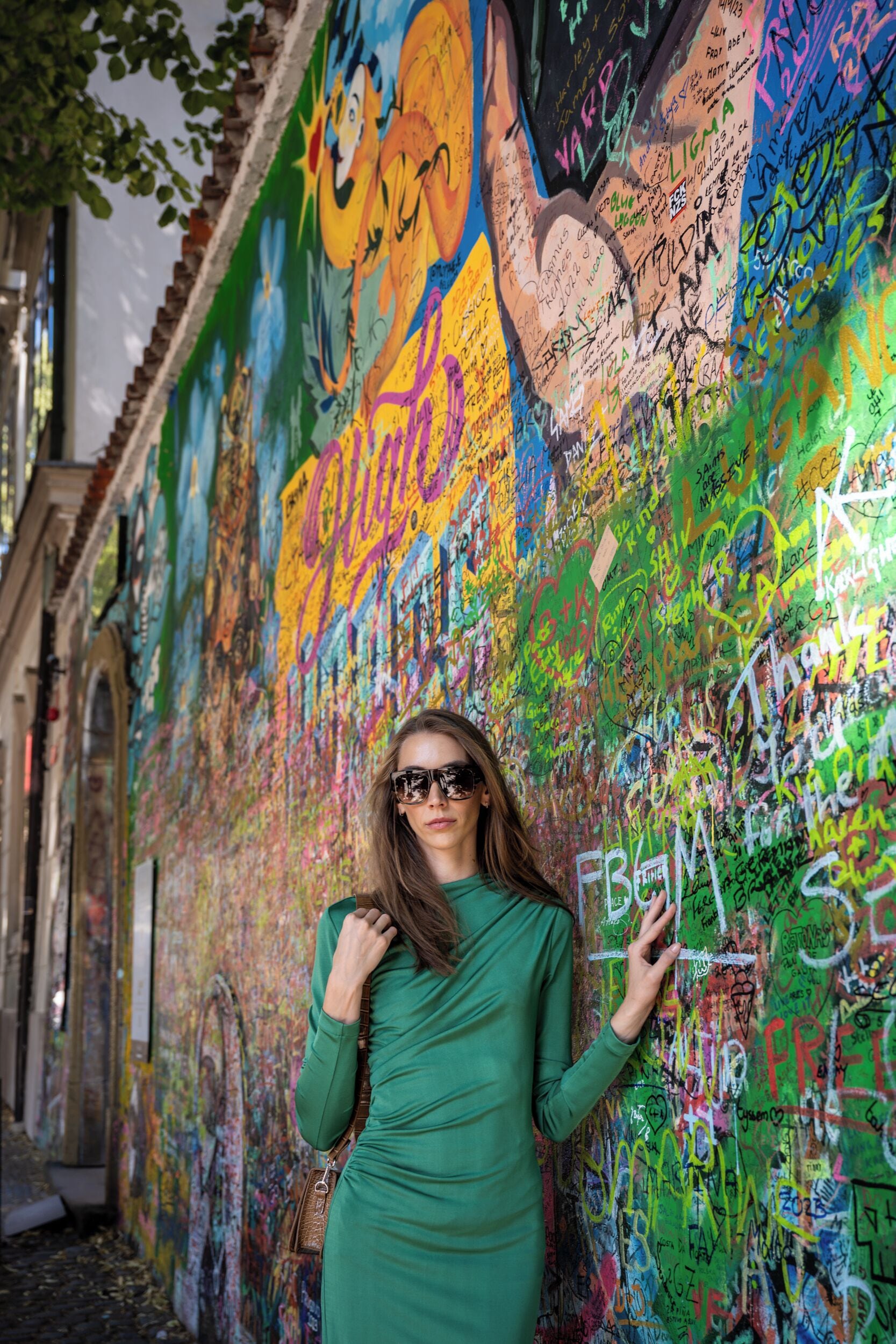 A person standing in front of a colorful graffiti-covered wall.