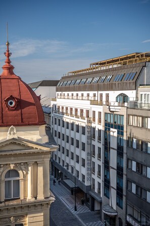 Un hotel con una cúpula roja, fachada blanca y numerosas ventanas.