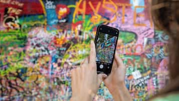 En person fotograferer en farverig væg med graffiti.