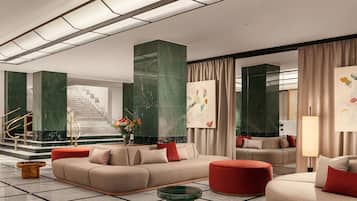 A modern lobby with a sofa, ottoman, and a coffee table.