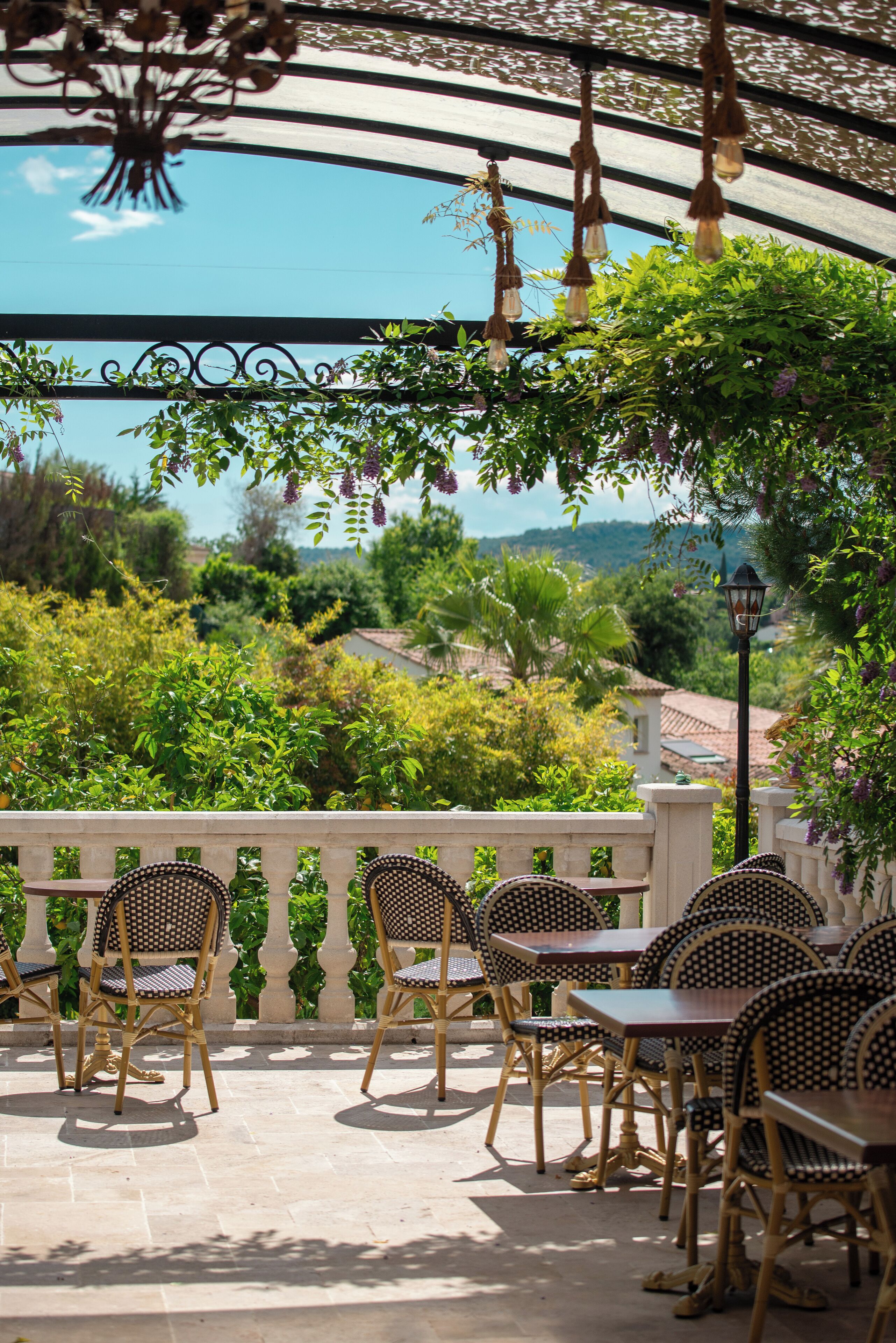 An outdoor patio with wicker furniture and a view of the countryside.