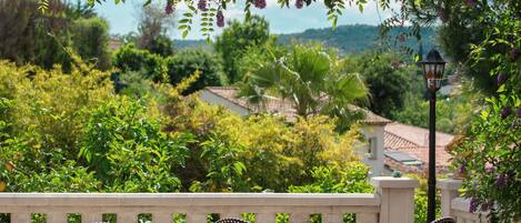 An outdoor patio with wicker furniture and a view of the countryside.