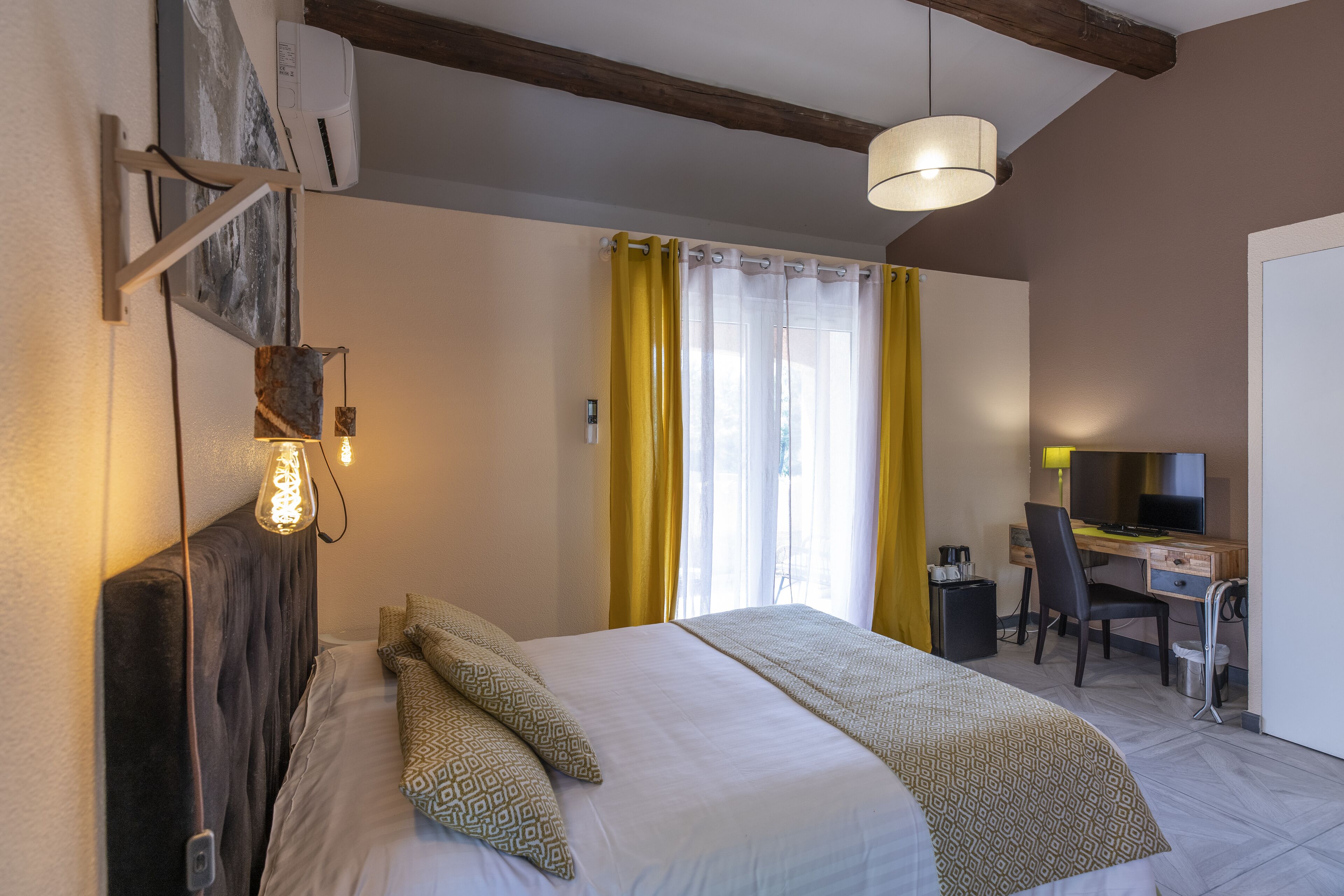 Una habitación de hotel con cama, escritorio, silla y televisor.