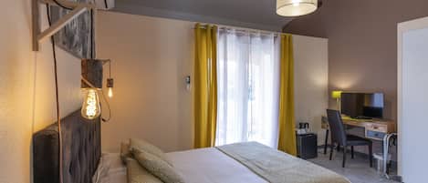 Una habitación de hotel con cama, escritorio, silla y televisor.