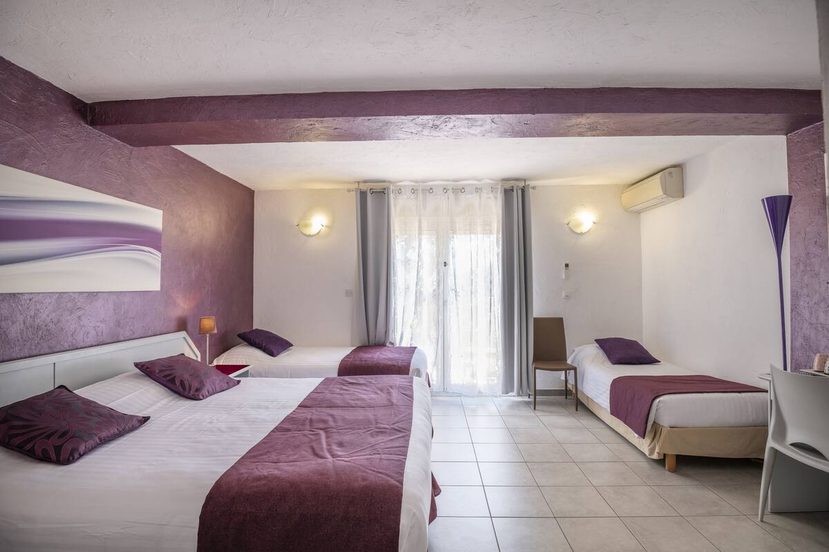 Ein Hotelzimmer mit zwei Betten, einem Schreibtisch und einem Stuhl.