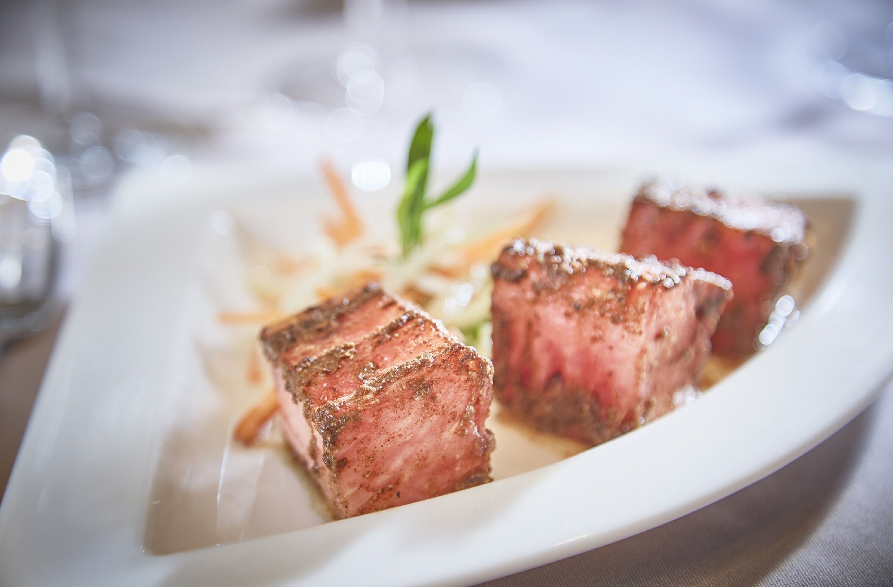 A plate of steak with a garnish.