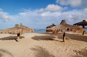 On the beach, white sand, sun loungers, beach umbrellas