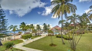 Ein Resort mit Pool, Palmen und Blick auf den Ozean.