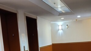 Eine Hotelhalle mit hochglänzendem schwarzen Boden, einem gemusterten Teppich und einem Oberlicht.