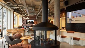 A modern interior with a fireplace, seating area, and a visible bar counter. - Inter-hotel Deauville Gare Continental (Deauville)