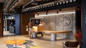 A reception area with a modern design, featuring a counter, a neon sign, and a display of wine bottles. - Inter-hotel Deauville Gare Continental (Deauville)