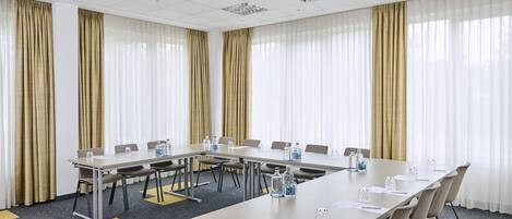 A conference room with a long table, chairs, and water bottles.