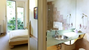 A modern bathroom with a glass sink, a shower, and a large mirror. - Hotel Watthalden (Ettlingen)