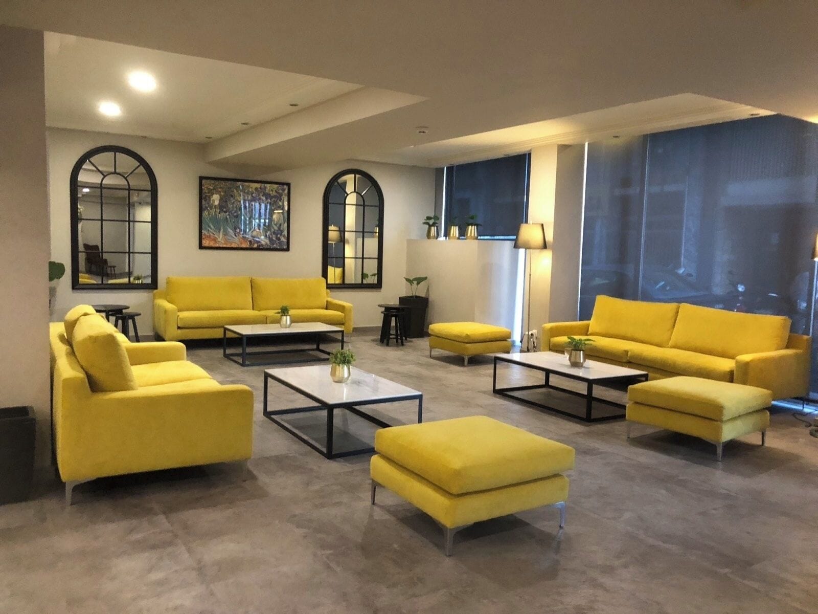 A modern living room with yellow sofas, a coffee table, and a large window with a view.