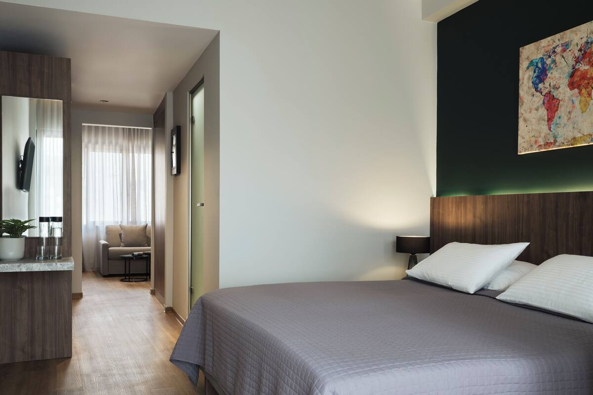 A modern hotel room with a large bed, a desk, and a chair.