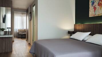 Et moderne hotelværelse med en stor seng, et skrivebord og en stol.