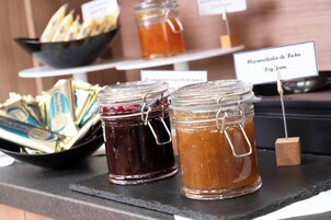 Dos tarros de vidrio con cierres metálicos, uno con un contenido rojo oscuro y otro de color marrón claro, etiquetados como 'Marmellata di Fichi Fig Jam'.