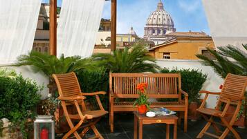 Relax on the terrace with a view of the iconic landmark, surrounded by lush greenery and a cozy seating area.