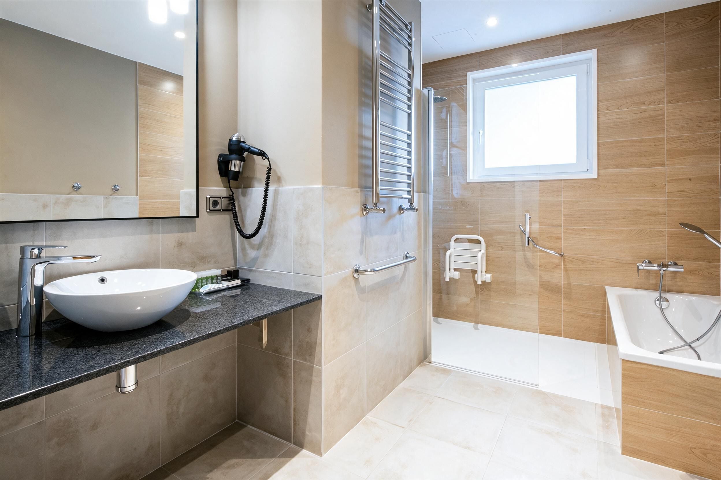 A modern bathroom with a large sink, a mirror, a towel rack, a shower, and a bathtub.