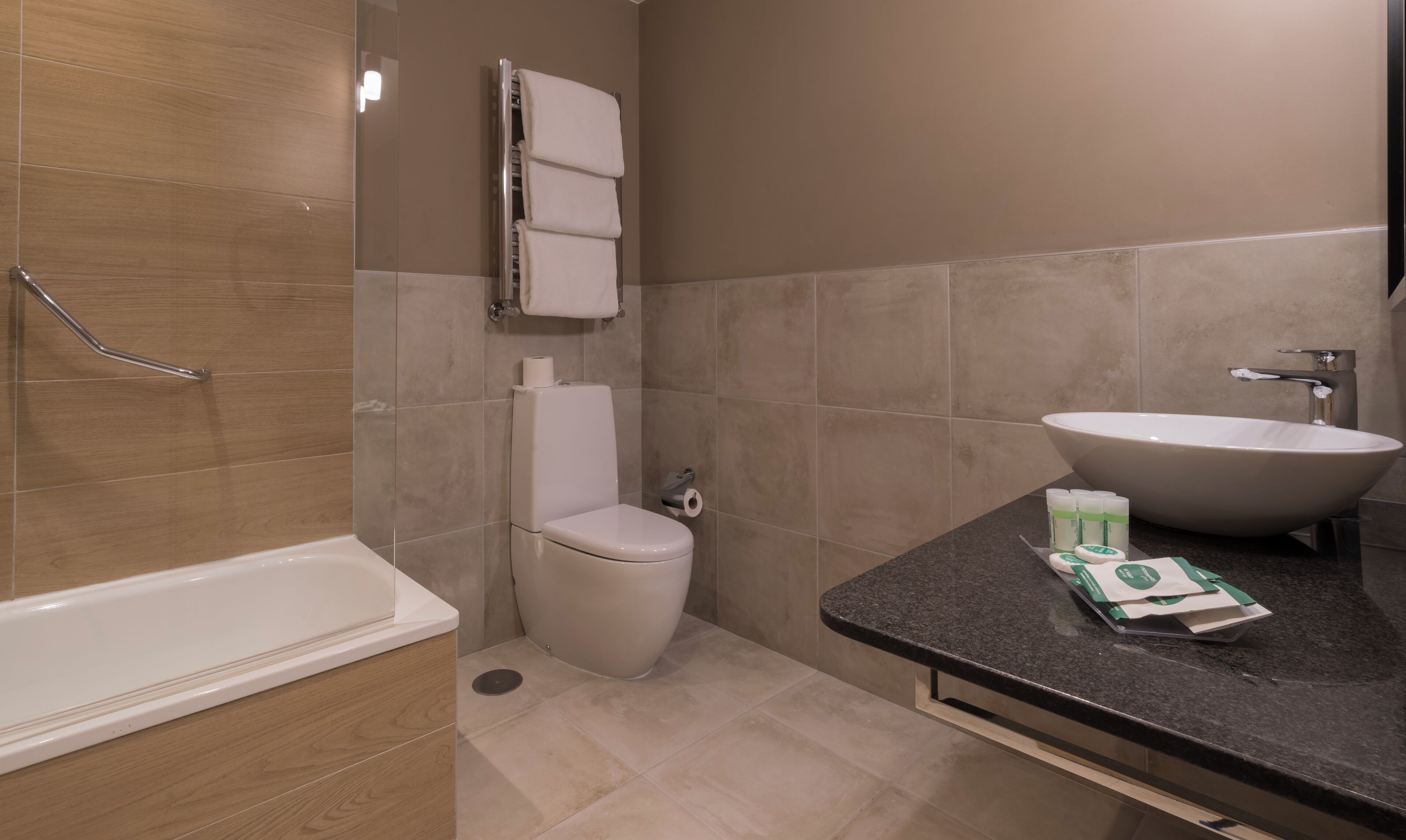 A modern bathroom with a bathtub, toilet, and sink.