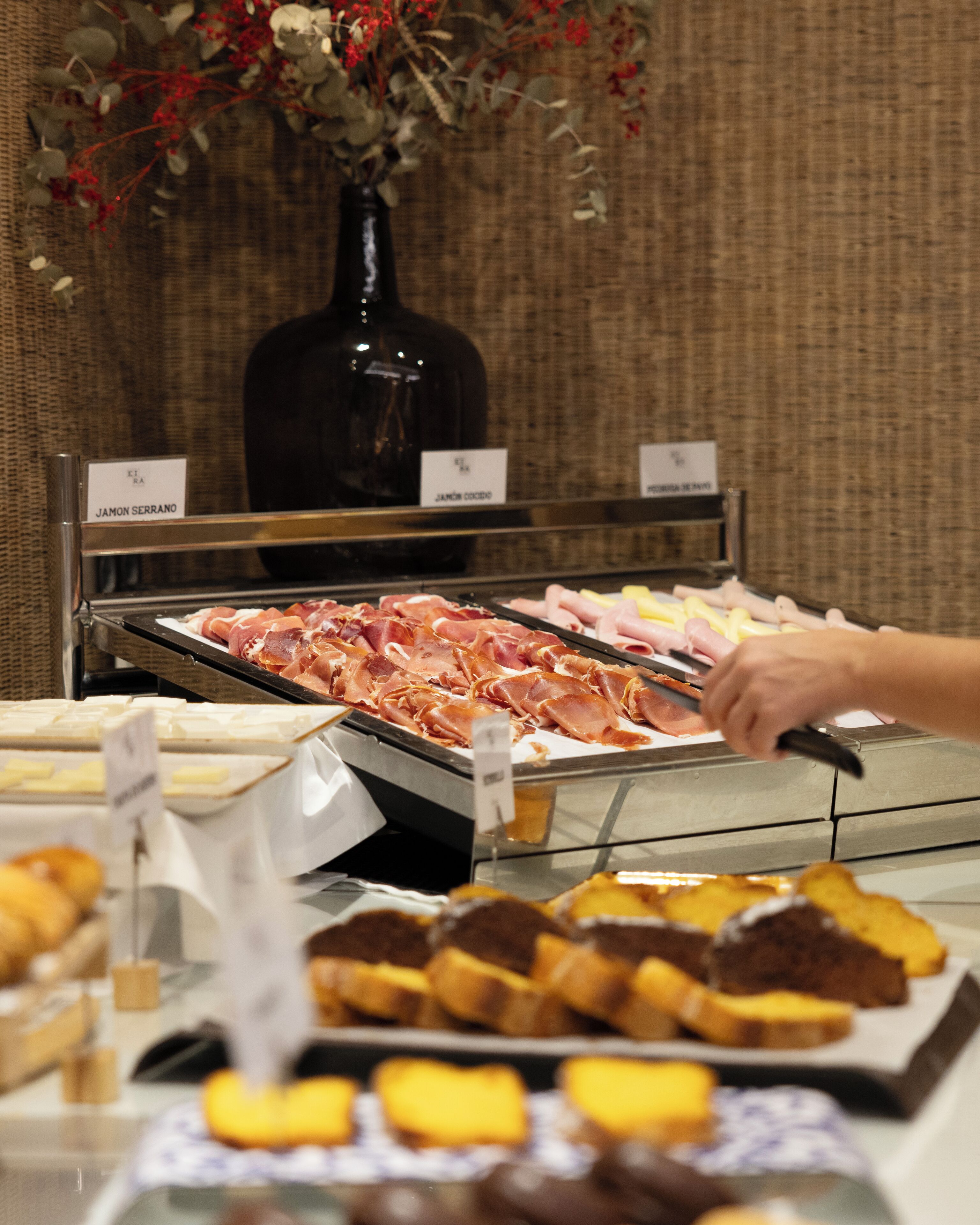 A buffet with various meats and pastries.