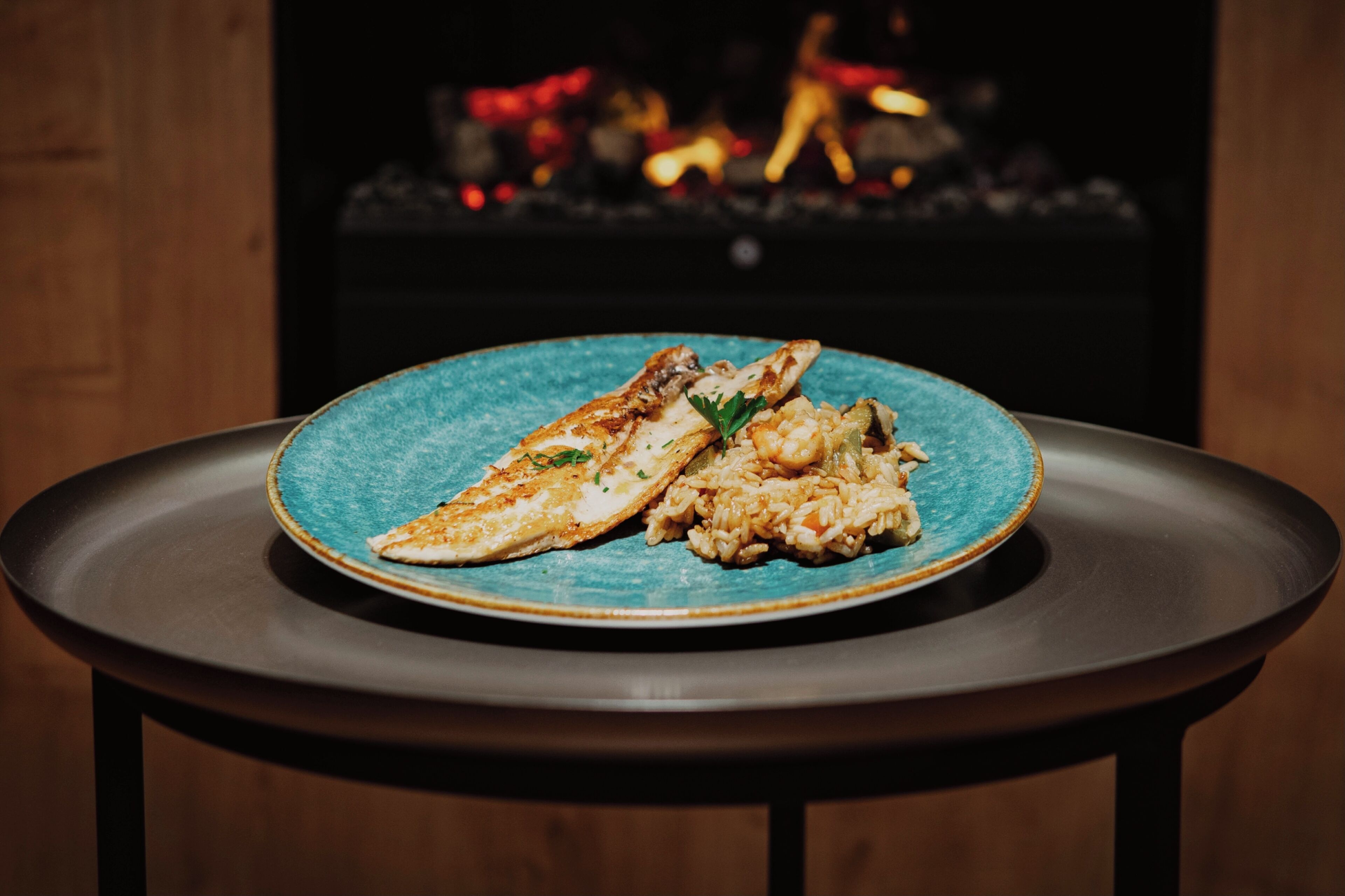 A plate of food on a table with a blurred background of a room.
