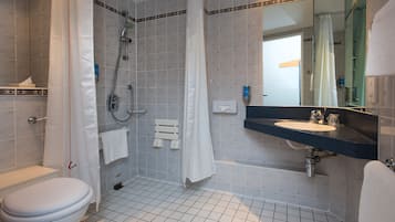 Un baño con inodoro, ducha, bañera y lavabo con espejo.