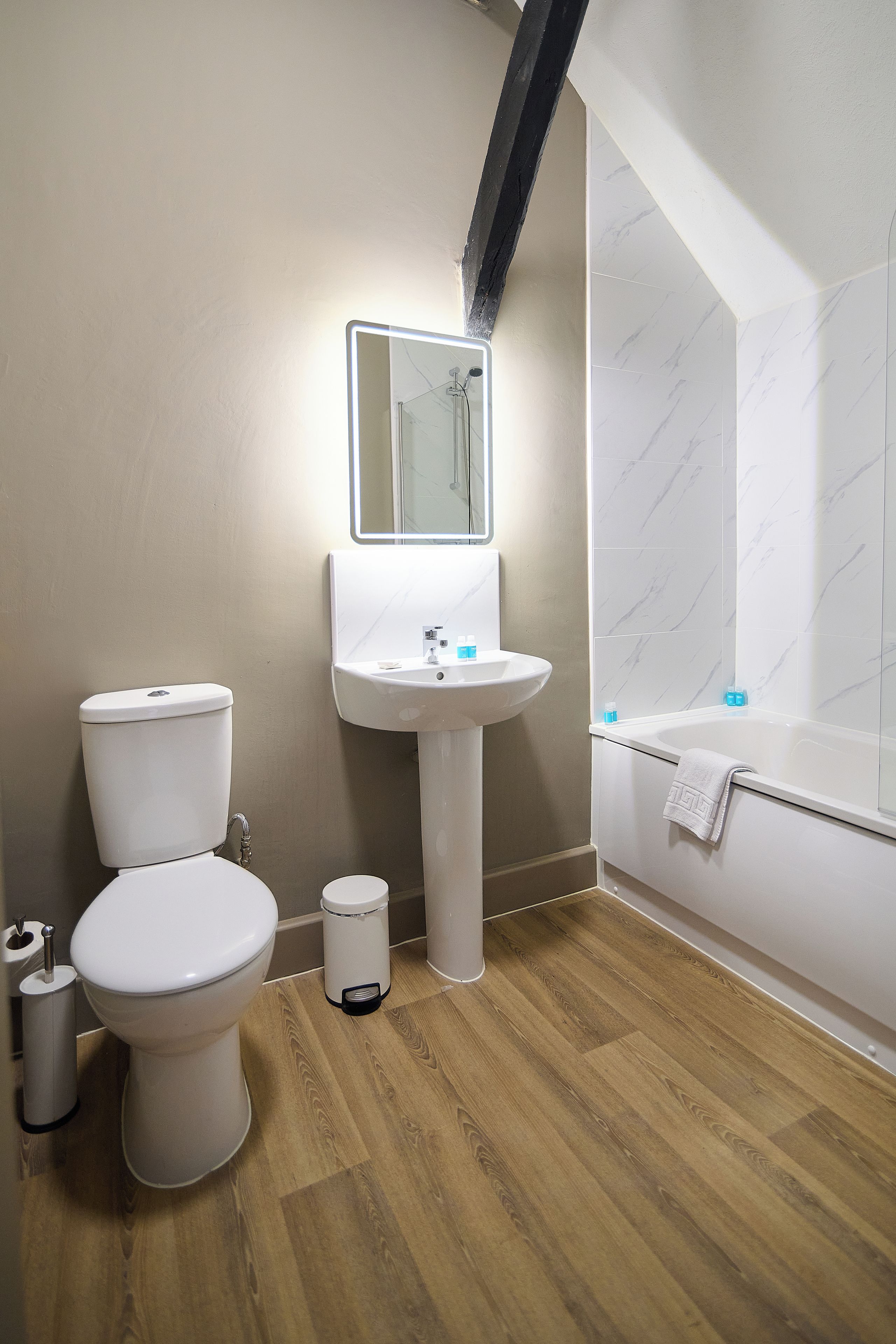 A modern bathroom with a toilet, sink, and shower.