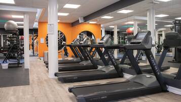 A gym with treadmills, exercise balls, and weight machines.