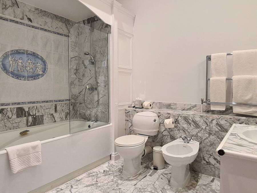 A bathroom with a bathtub, a bidet, a toilet, and a sink.