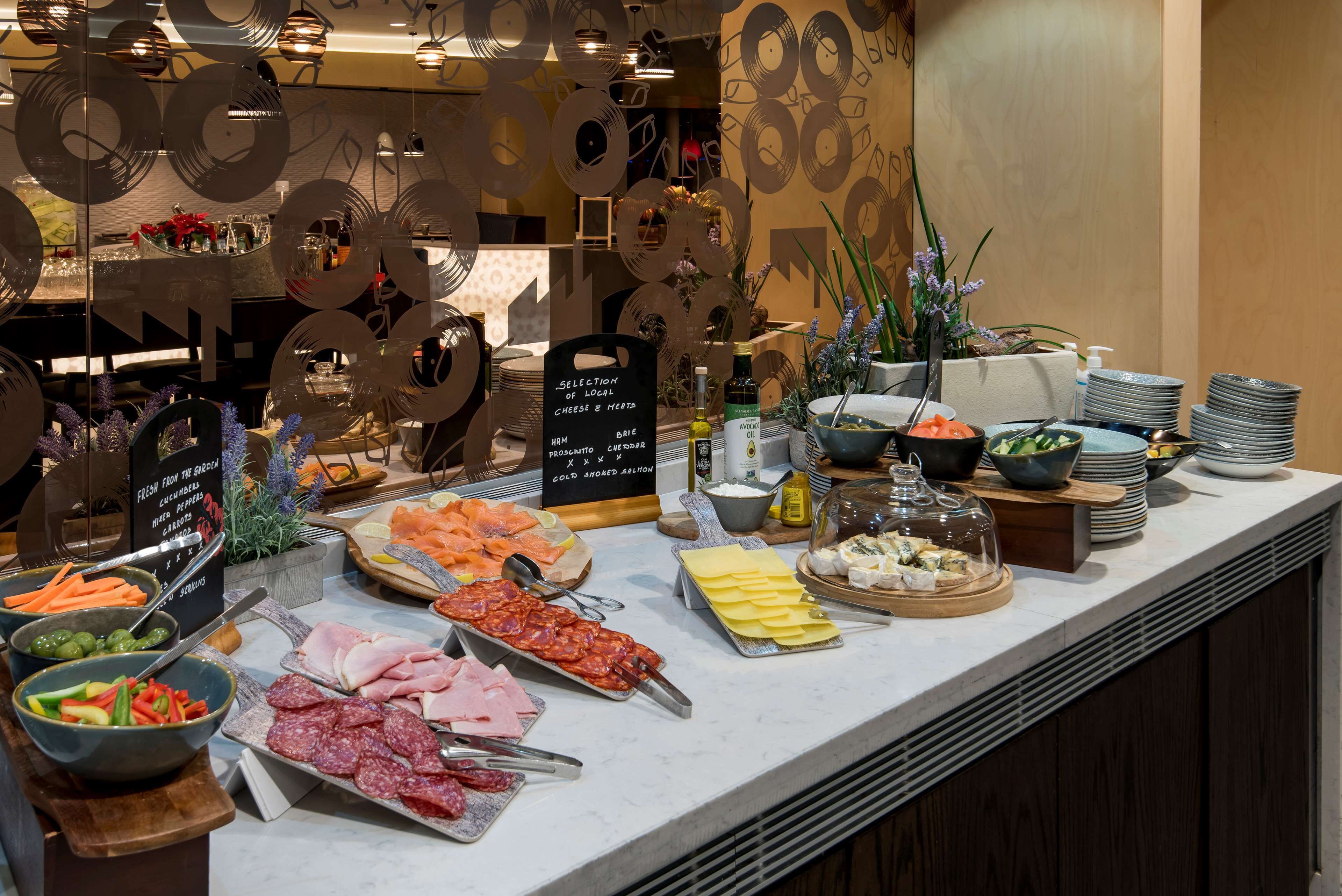 A buffet with various food items including meats, cheeses, and vegetables.