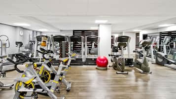 A gym with various exercise equipment, including treadmills, stationary bikes, and weight machines.