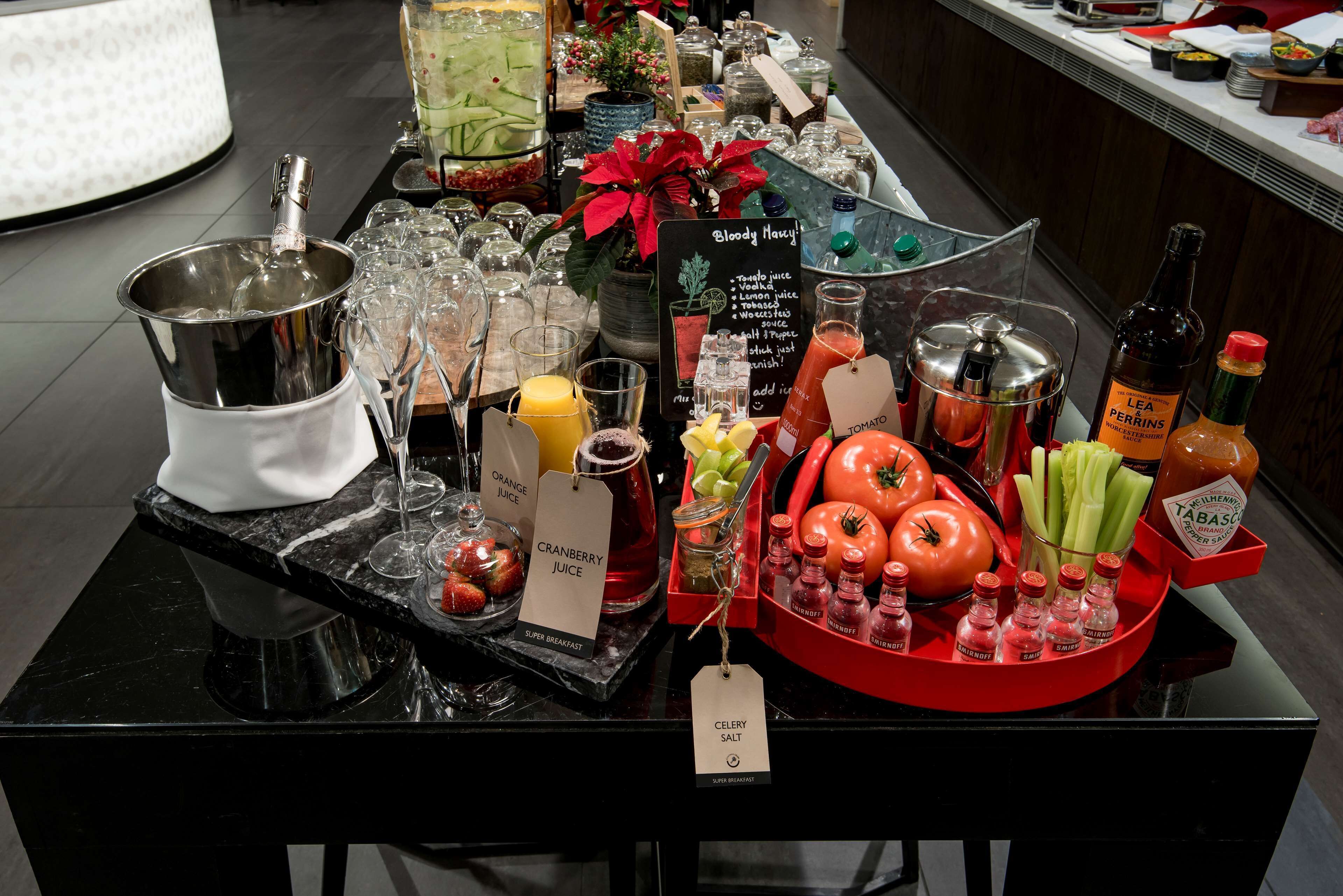 Una mesa de buffet con diversos alimentos, bebidas y salsas.